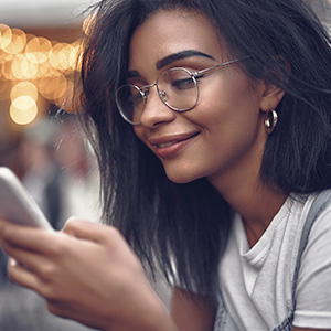 young woman on her smart phone wearing eye glasses