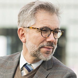 mature man in a tweed suit wearing eye glasses
