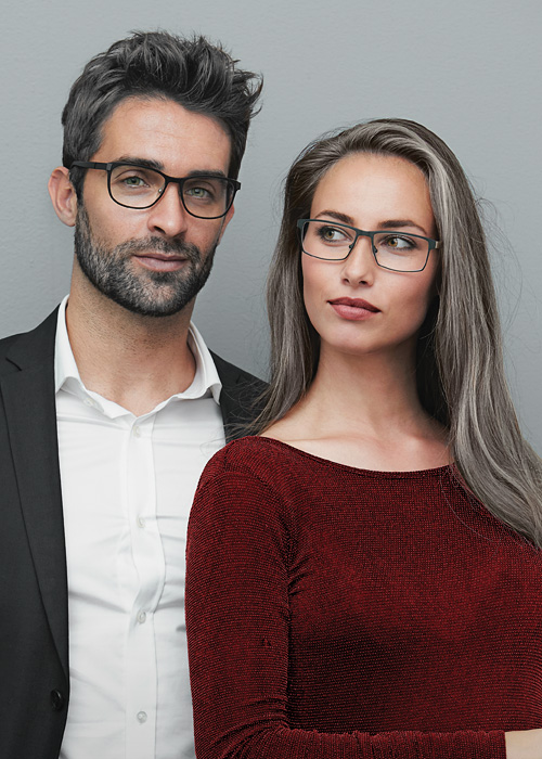 fashionable middle aged couple in a suit and evening gown wearing eyeglasses