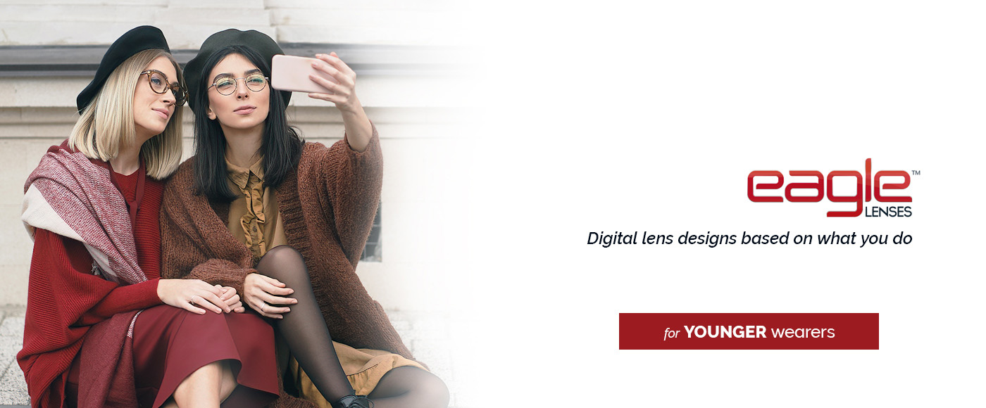 two young women dressed in fashionable fall attire, sitting and taking a selfie together