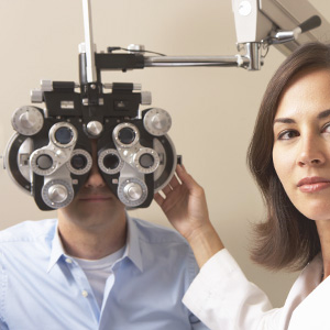 man having eyes examined with a manual phoropter